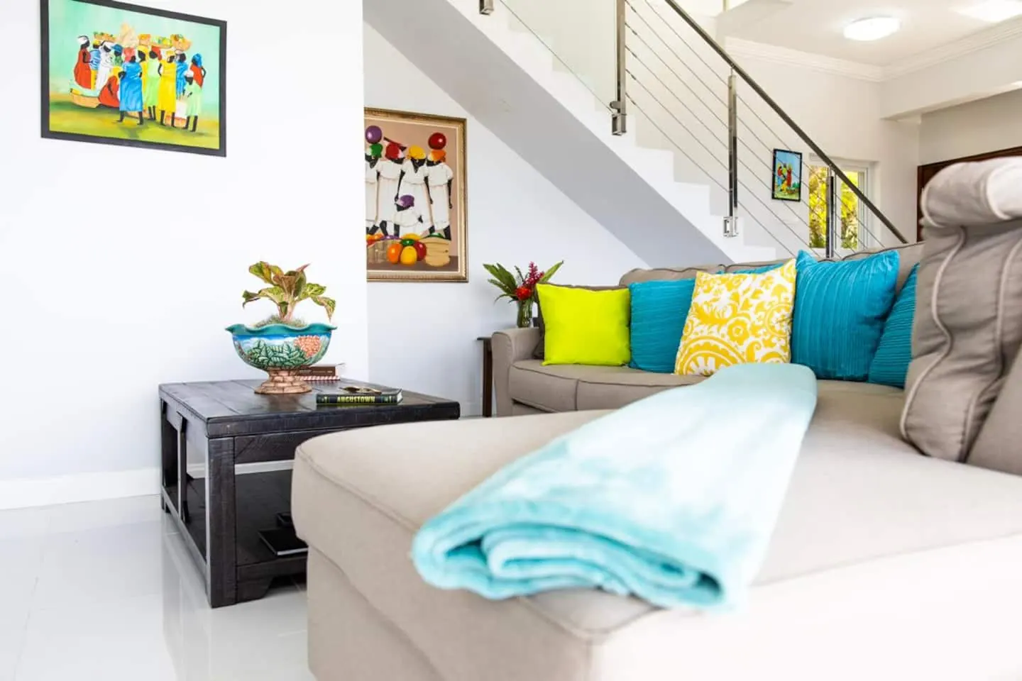 Living room sofa with colourful cushions and a chaise section.