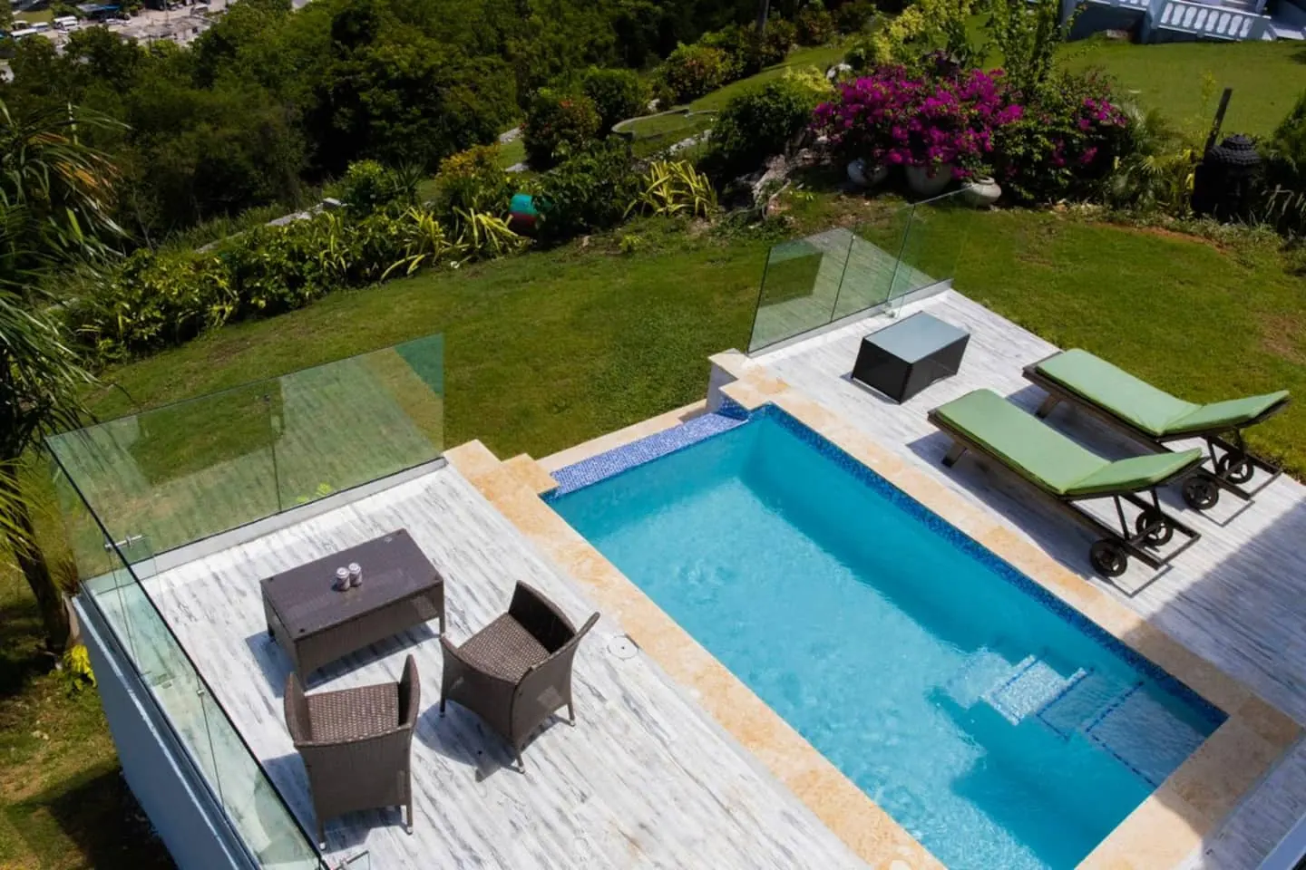 Pool terrace with an outdoor table, chairs and sun loungers.