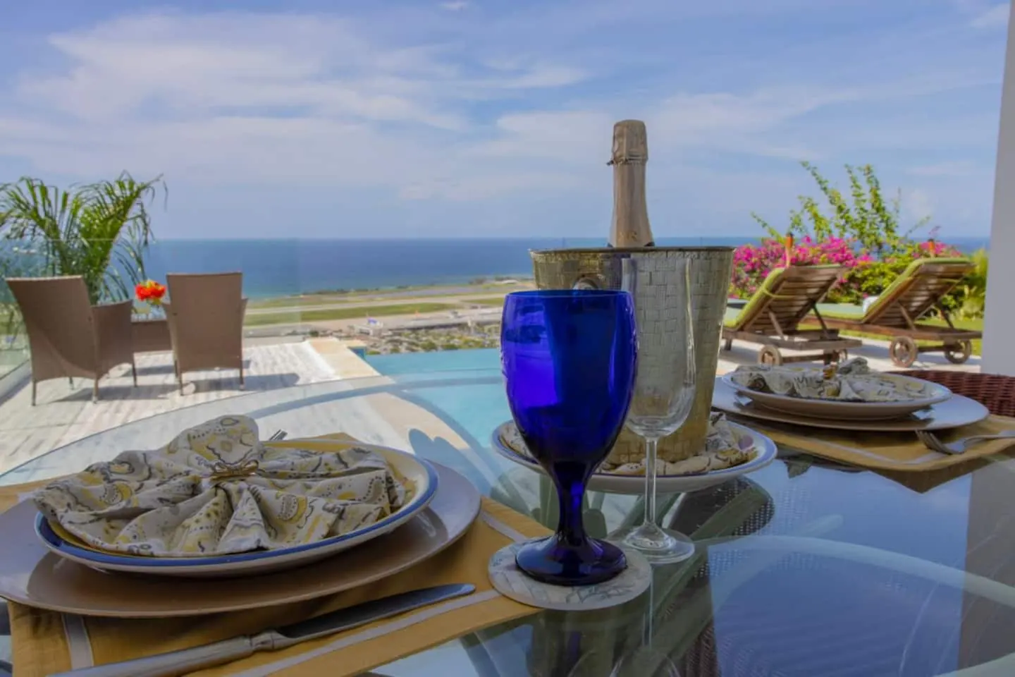 Patio dining beside the pool terrace, with runway and sea views.