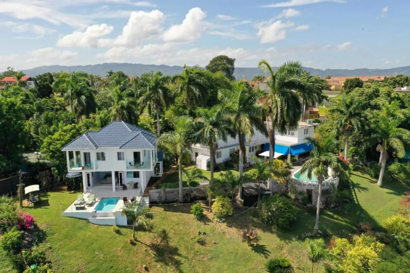 Aerial view: Glory is the smaller blue-roofed house on the left.