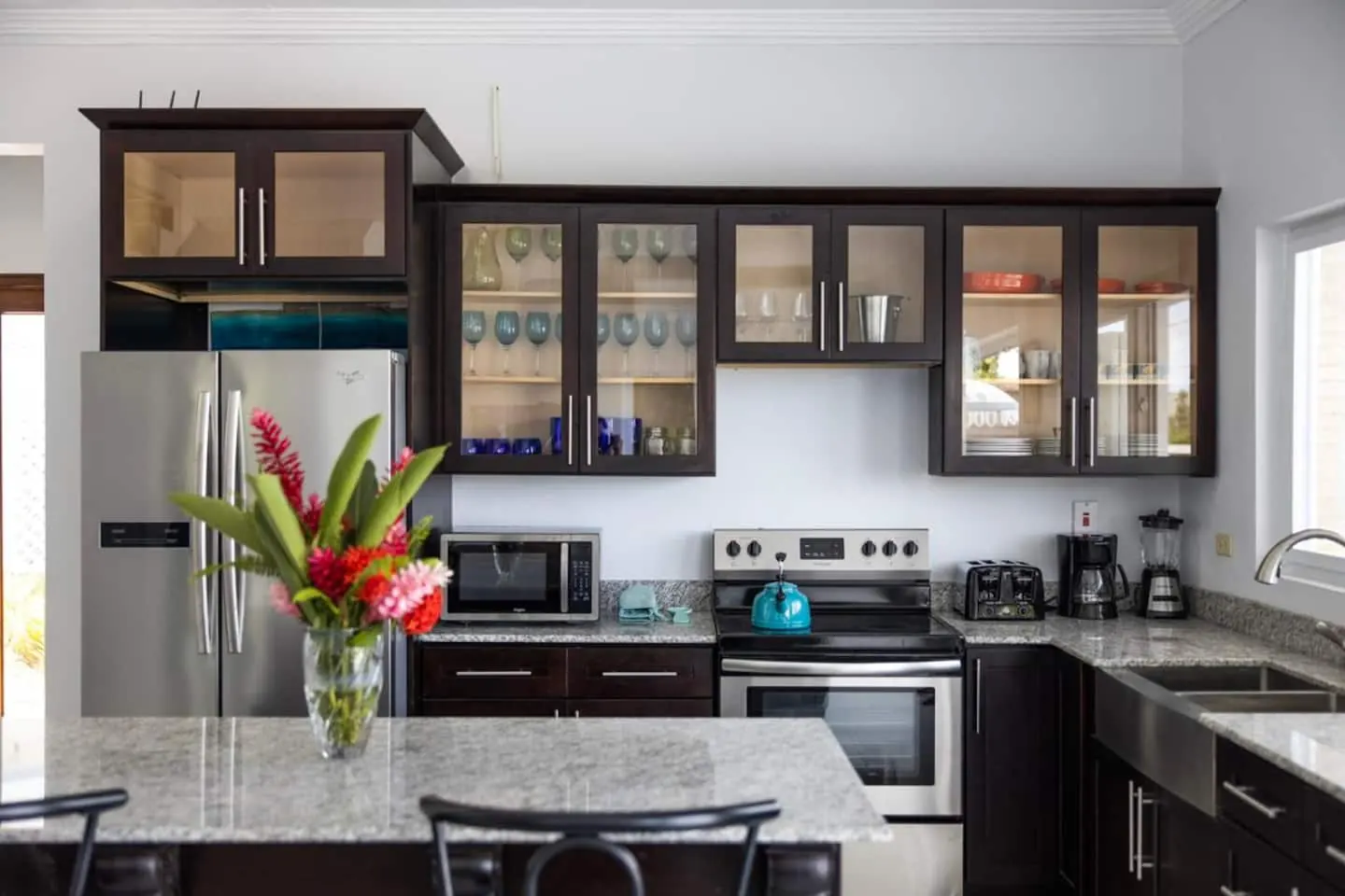 Kitchen with refrigerator, stove and oven, microwave, toaster, coffee maker and blender.
